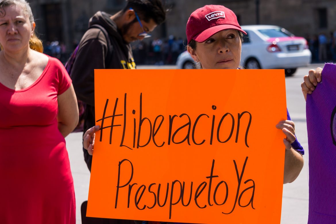 La liberación de recursos para programas de protección a las mujeres es una problemática constante detrás de estas situaciones de abuso laboral y falta de atención a víctimas. En la fotografía, una mujer se manifiesta por la liberación de presupuesto para la Red Nacional de Refugios en 2019. CIMACFoto: Sammi Bushman.