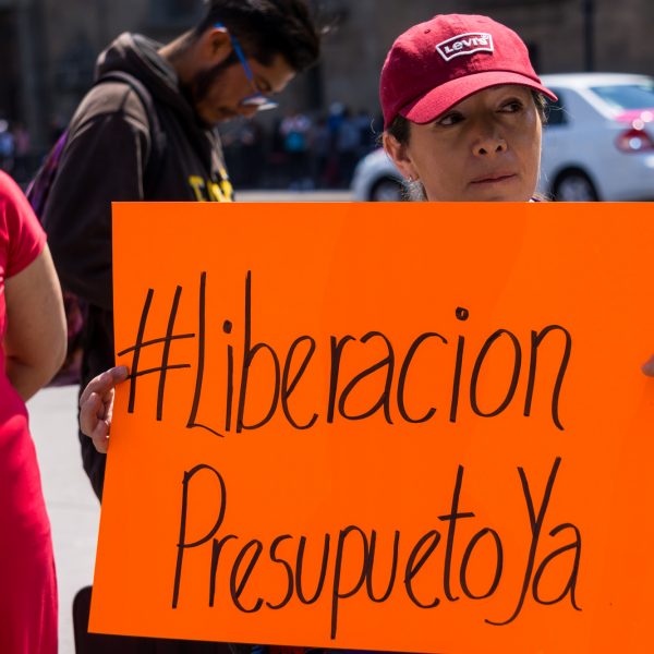 La liberación de recursos para programas de protección a las mujeres es una problemática constante detrás de estas situaciones de abuso laboral y falta de atención a víctimas. En la fotografía, una mujer se manifiesta por la liberación de presupuesto para la Red Nacional de Refugios en 2019. CIMACFoto: Sammi Bushman.